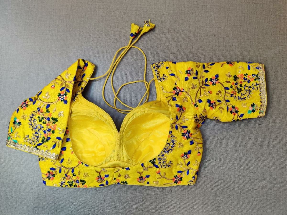 Buy a yellow silk saree blouse that has a sweetheart neck, 3/4th sleeves, and hook closure. Yellow blouse crafted in hammered silk with beautiful floral embroidery work. This charming blouse surely fetches you compliments for your rich sense of style. Complement your look with statement jewelry and high heels to complete the ensemble.- Back View