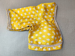 Buy this look in the gaiety of spring with this enchanting yellow blouse. Tailored in silk, it features a white polka dot print and neck embroidery and gets its finishing touches with hook closure at the back. Perfect blouse for Haldi functions. Elevate your Indian saree style with exquisite readymade sari blouse, embroidered saree blouses, Banarasi sari blouse, and designer sari blouse from Pure Elegance Indian clothing store in the USA.- Folded View