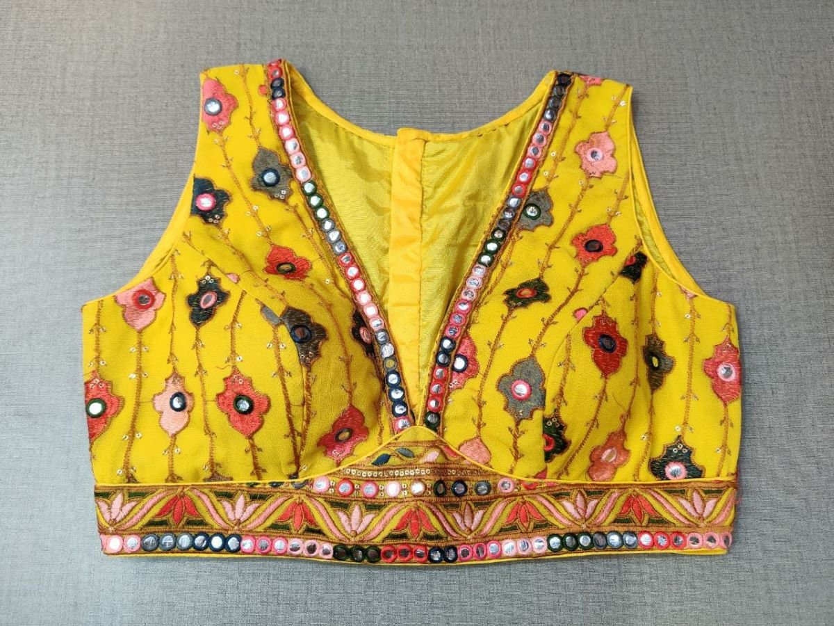 Buy a Multi-Color Embroidery blouse crafted in hammered yellow silk with mirrorwork. Tailored with sleeveless shoulders, the blouse features a smocked back for comfort and style, and button closure. Give your ethnic look a dazzling update with this yellow blouse. Buy this designer blouse in the USA from Pure Elegance. - Front View
