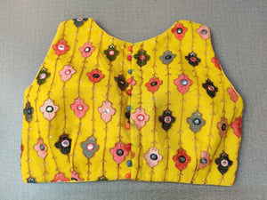 Buy a Multi-Color Embroidery blouse crafted in hammered yellow silk with mirrorwork. Tailored with sleeveless shoulders, the blouse features a smocked back for comfort and style, and button closure. Give your ethnic look a dazzling update with this yellow blouse. Buy this designer blouse in the USA from Pure Elegance. - Back View