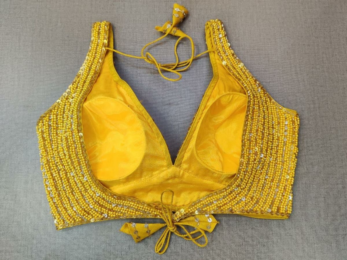 Buy this blouse as a rich add-on to glam up your look. The blouse features a yellow pearl embroidery and tie-up closure at back. Team this blouse with a lovely solid saree to look gorgeous and create a stunning and beautiful look Buy this designer blouse in the USA from Pure Elegance. - Back View
