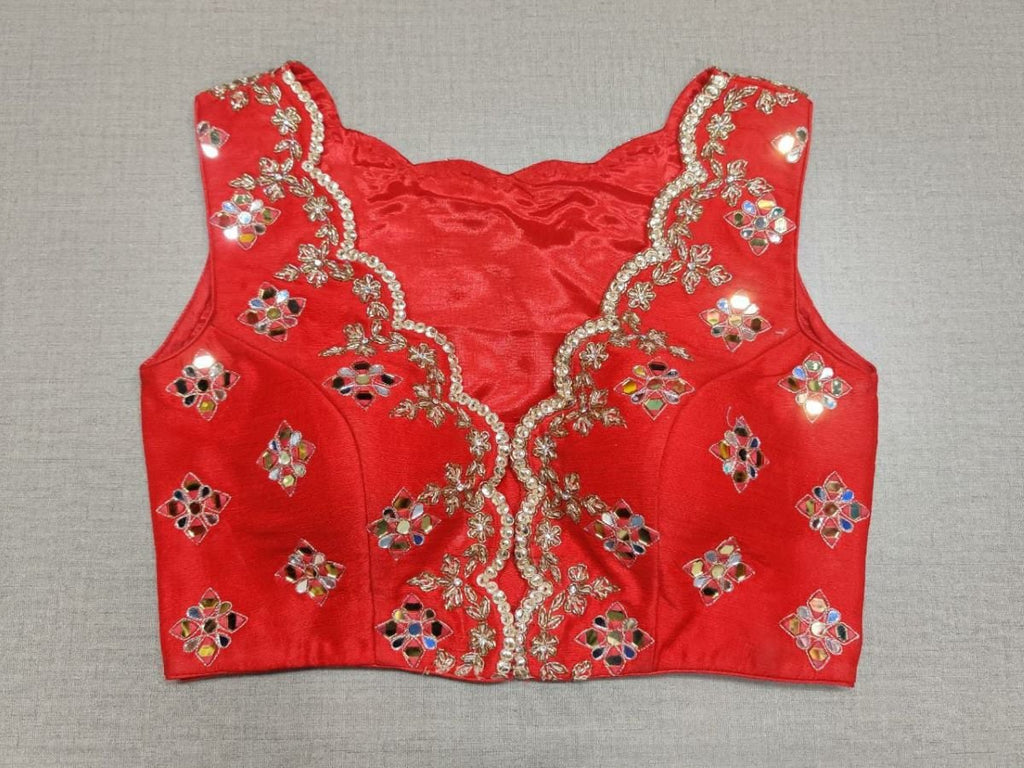 Buy equal parts glamorous, subtle and sophisticated, this red blouse is a fool-proof addition to any look. Features a mirror embroidered work, sleeveless with beautiful neck design, and hook closure in the front. The blouse is a seasonless must-have. Buy this designer blouse in the USA from Pure Elegance.- Front View