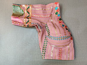 Buy and create a look scintillating and smoldering hot in this pink blouse. The blouse is embroidered beautifully in multicolors and designed with 3/4th sleeves, a V-shaped neck in the front, and a U shape back with tie-up and tassels. Wear it and turn into a fashion diva, in a snap. Buy this designer blouse in the USA from Pure Elegance. - Folded View