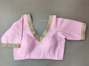Buy a beautiful pink color Indian saree designer blouse with embroidery. You can pair up with any Indian Saree for any occasion to make your look elegant. A pink blouse is a woven design padded saree blouse that has a V neck,  a beautiful back, and hook closure. You can pair it with any Indian Saree, Banarasi Silk Sarees, and Chanderi Silk sarees. Buy it from Pure Elegance sari blouse from Pure Elegance Indian clothing store in the USA.- Front View