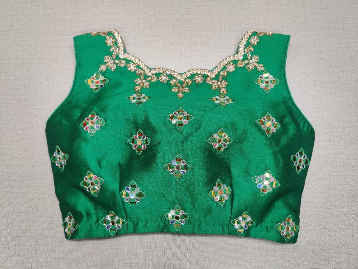 Buy exquisite green color mirror work designer. It has a beautiful V-neck and hooks closure. Pairs it with a contrasting saree to make your look more graceful. Perfect blouse for cocktail parties. Elevate your Indian saree style with exquisite readymade sari blouse, embroidered saree blouses, Banarasi sari blouse, and designer sari blouse from Pure Elegance Indian clothing store in the USA.- Back View