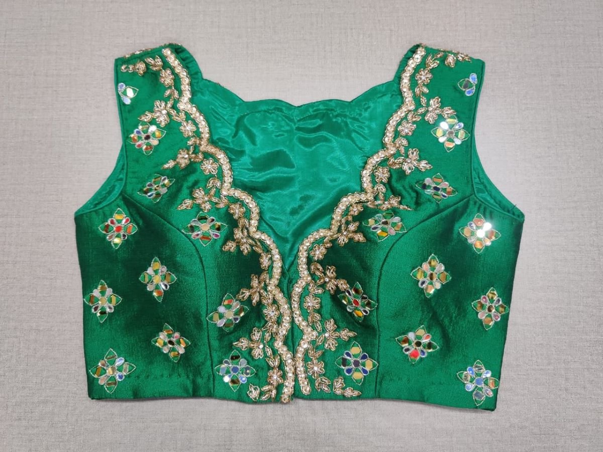 Buy exquisite green color mirror work designer. It has a beautiful V-neck and hooks closure. Pairs it with a contrasting saree to make your look more graceful. Perfect blouse for cocktail parties. Elevate your Indian saree style with exquisite readymade sari blouse, embroidered saree blouses, Banarasi sari blouse, and designer sari blouse from Pure Elegance Indian clothing store in the USA.- Front View