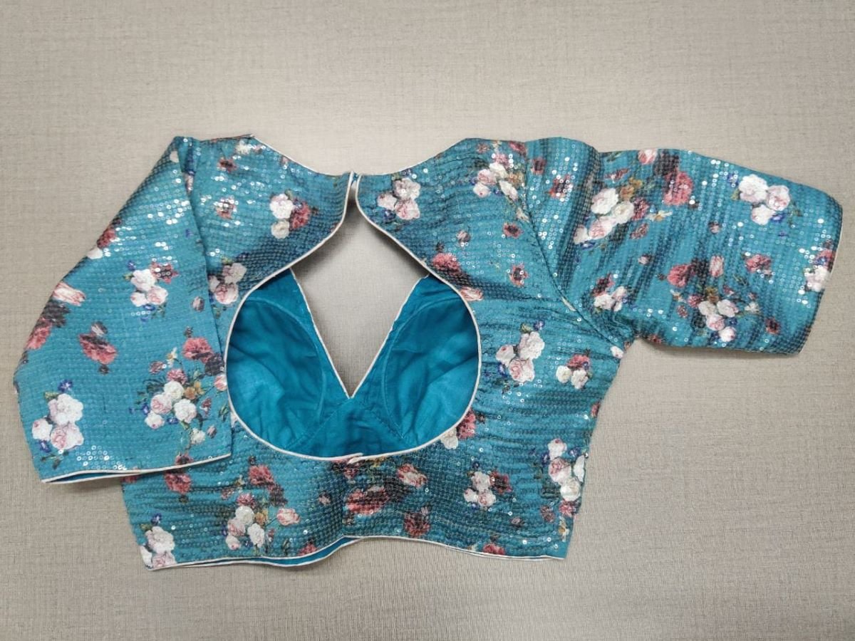 Buy a blue silk saree blouse that has a V neck, 3/4th sleeves, and hook closure. Blue blouse crafted in hammered silk with beautiful floral embroidery work. This charming blouse surely fetches you compliments for your rich sense of style. Complement your look with statement jewelry and high heels to complete the ensemble.- Back View