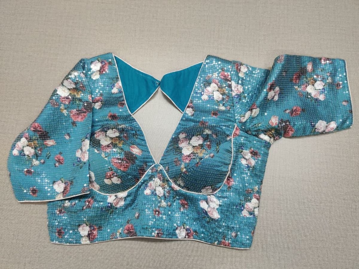 Buy a blue silk saree blouse that has a V neck, 3/4th sleeves, and hook closure. Blue blouse crafted in hammered silk with beautiful floral embroidery work. This charming blouse surely fetches you compliments for your rich sense of style. Complement your look with statement jewelry and high heels to complete the ensemble. - Front View