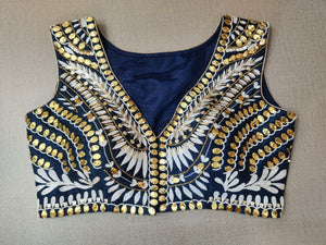 Buy and enhance the look of your contemporary ethnic wear by wearing this navy blouse. Features a golden and white embroidery, a V neck, and a hook closure. This charming blouse surely fetches you compliments for your rich sense of style. Complement your look with statement jewelry and high heels to complete the ensemble. Buy this designer blouse in the USA from Pure Elegance. - Front View