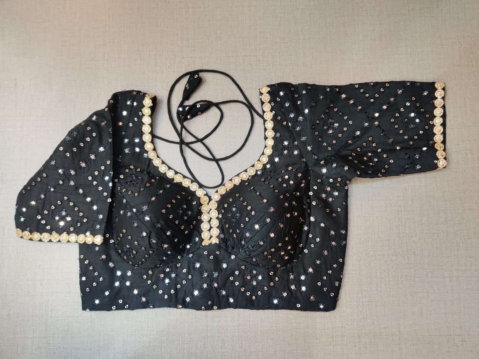 Buy this blouse to righten up your festive nights with this enchanting black sequin embroidered sleeveless blouse. Featuring sequin embroidery on the blouse, U shape front & back,hook closure and tie up . This blouse can elevate the simplest of outfits. Buy this designer blouse in the USA from Pure Elegance. - Front View
