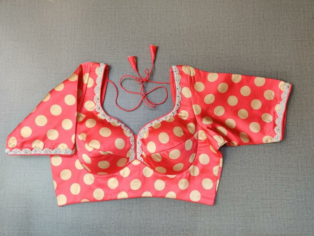 Buy striking and stylish, this orange blouse will effortlessly elevate your summer looks. Featuring a statement golden polka print, the blouse is designed U neck and hook closure and tie up. This blouse is a rich add-on to glam up your look. Team this blouse with a lovely solid saree to look gorgeous and create a stunning and beautiful look. Buy this designer blouse in the USA from Pure Elegance. - Front View