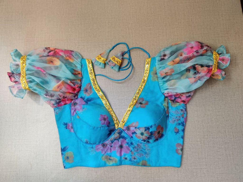 Buy a palette of beautiful and adorned sequin embroidery details on the neck, this georgette floral foam blouse indulges the wearer in the sweet charm of summer. Tailored in mesh and designed with puffy sleeves, the top features are short sleeves, a hook, and a tie-up for closure. Pair it with a beautiful Indian georgette saree to have an elegant look. - Front View