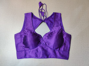 Buy a Purple readymade saree blouse that has sleeveless, a V-neck, hook-and-eye closure on the back, and tie-up detail on the back. This readymade saree blouse is a must-have piece. Wear it with a contrasting saree or even with a contrasting lehenga skirt to complete the look.- Front View