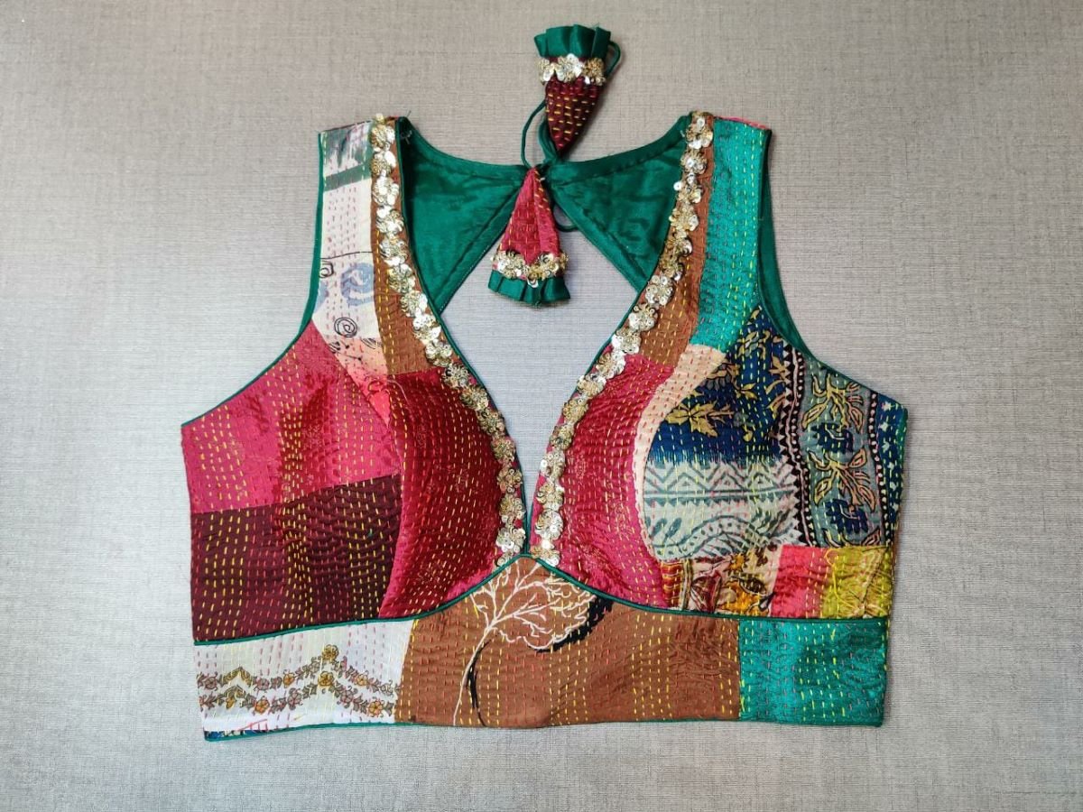 Buy a green multicolor printed padded saree blouse, that has a V-neck, short sleeves, tie-up detail at the back, hook, and eye closure. Let your aura shine throughout by wearing this designer saree blouse. Pair this fashionable blouse with a beautiful printed sari and statement neck piece and you are good to go.- Front View