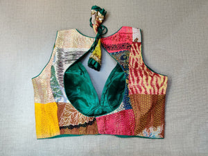 Buy a green multicolor printed padded saree blouse, that has a V-neck, short sleeves, tie-up detail at the back, hook, and eye closure. Let your aura shine throughout by wearing this designer saree blouse. Pair this fashionable blouse with a beautiful printed sari and statement neck piece and you are good to go.- Back View