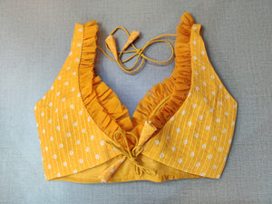 Buy the yellow saree blouse that has strappy sleeves and a V-neck with ruffles, hook-and-eye closure on the back, and tie-up detail on the back, for more grace there are beautiful white dots. This readymade saree blouse is a must-have piece. Wear it with a contrasting saree or even with a contrasting lehenga skirt to complete the look. - Back View