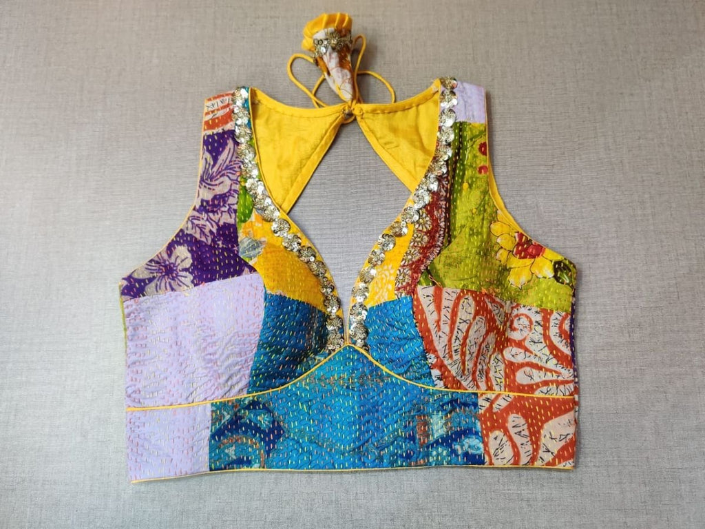 Buy a yellow multicolor printed padded saree blouse, that has a V-neck, short sleeves, tie-up detail at the back, hook, and eye closure. Let your aura shine throughout by wearing this designer saree blouse. Pair this fashionable blouse with a beautiful printed sari and statement neck piece and you are good to go.- Front view