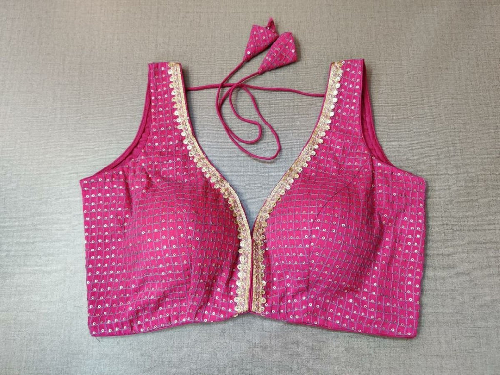 Buy minimal yet stylish, this pink blouse with golden embroidered lace and timeless check print will brighten up your festive soirees. Featuring an embroidered front & back, the blouse is V-neck in front and U shape in back, and sleeveless with hook closure and tie up. Wear it with a contrasting saree or even with a contrasting lehenga skirt to complete the look.- Front View