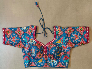 Buy the Blue & red block-printed saree blouse, which has an elephant print, U-neck with mirror work, short sleeves with mirror work, a tie-up at the back, and hook closures. This saree blouse looks graceful and elegant and is extremely comfortable. Style it with a pretty saree or skirt, statement jewelry, and heels to look your best.- Front View