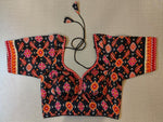 Buy this Black and Orange Block Printed, padded saree Blouse that has Short Sleeves, U neck with mirror work lace, hook, and tie-up closure, Pair it with a beautifully printed sari and statement neck piece and you are good to go! Elevate your Indian saree style with exquisite readymade sari blouses, embroidered saree blouses, Banarasi sari blouses, and designer sari blouses from Pure Elegance Indian clothing store in the USA.- Front View