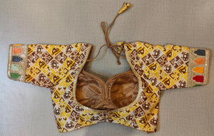 Buy the Yellow and Brown-color woven-design Jaipuri printed saree blouse that has embroidery work lace on the sleeves, U neck, short sleeves hook and eye closure at the front, and a tie-up fastening at back. This saree blouse is a must-have piece this festive season. Wear it with a contrasting saree or even with a contrasting lehenga skirt to complete the look.- Back view