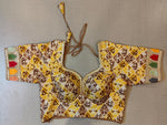 Buy the Yellow and Brown-color woven-design Jaipuri printed saree blouse that has embroidery work lace on the sleeves, U neck, short sleeves hook and eye closure at the front, and a tie-up fastening at back. This saree blouse is a must-have piece this festive season. Wear it with a contrasting saree or even with a contrasting lehenga skirt to complete the look.- Front View