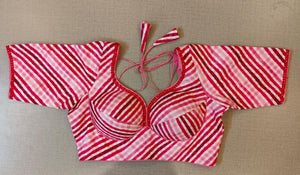 Buy pink printed saree blouse, has a U-neck, short sleeves, a hook, and a tie-up closure at the back. Drape a saree over this pretty blouse and be the start of any function. You can also style it with a palazzo to create a fusion outfit. Elevate your Indian saree style with exquisite readymade sari blouses, embroidered saree blouses, Banarasi sari blouses, and designer sari blouses from Pure Elegance Indian clothing store in the USA.- Front View