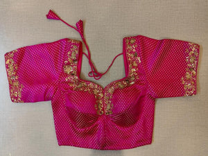 Buy the pink print saree blouse that has a U-neck with embroidery, short sleeves with embroidery, a tie-up at the back, and hook closures. .- Front View