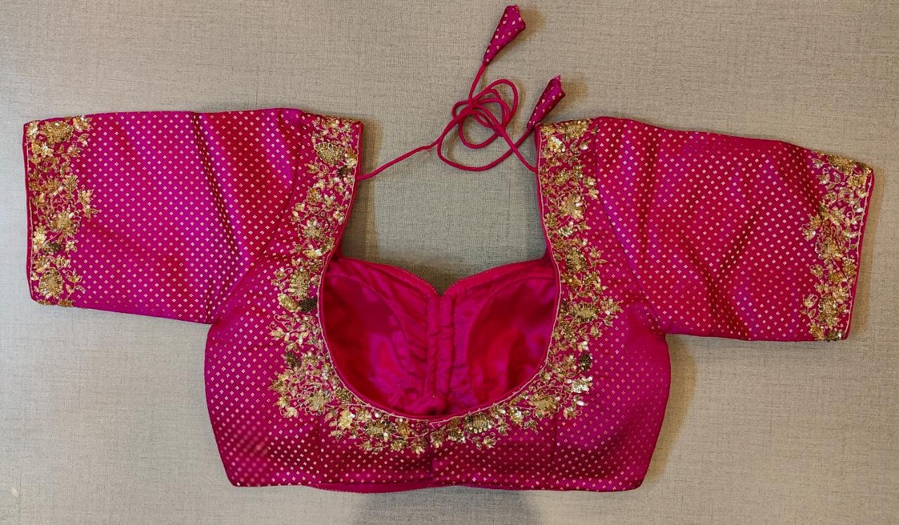 Buy the pink print saree blouse that has a U-neck with embroidery, short sleeves with embroidery, a tie-up at the back, and hook closures. .- Back View