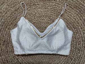 Solid white blouse crafted in hammered silk. Tailored with strappy shoulders, the blouse features a smocked back for comfort and style, and a zip closure. Give your ethnic look a dazzling update with this white silk blouse. Buy this designer blouse in USA from Pure Elegance. -Back View