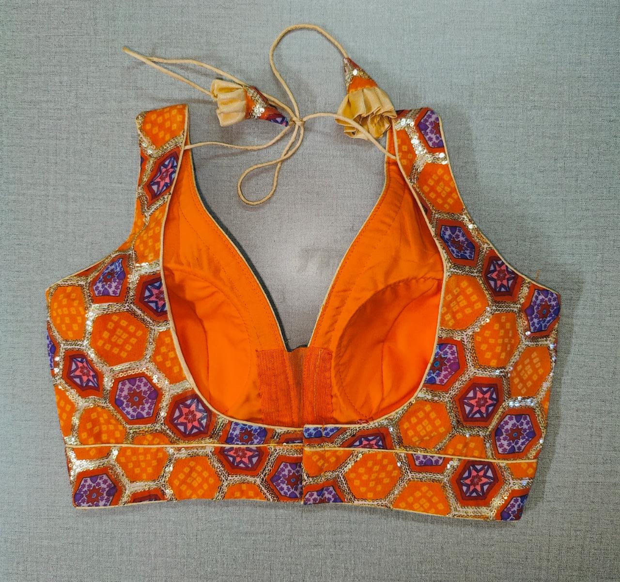 Beautifully designed orange and blue bhandej printed saree blouse. Pair it with a bandhani saree and bhandej sarees to create a beautiful Indian festival look. Buy Indian saree blouses, readymade saree blouses, and designer blouses for sarees from Pure Elegance Indian fashion store in USA.-Back View