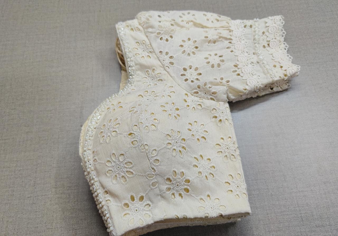 Buy white color Chikankari embroidery work saree blouse, has a U-neck, half puffy sleeves with hook & tie-up at the back. Pair it with cotton sarees to have a smooth and elegant look this summer. Elevate your Indian ethnic sarees with beautiful readymade sari blouses, embroidered saree blouses, Banarasi saree blouses, designer sari blouses, and choli-cut blouses from Pure Elegance Indian fashion store in USA.-Folded View