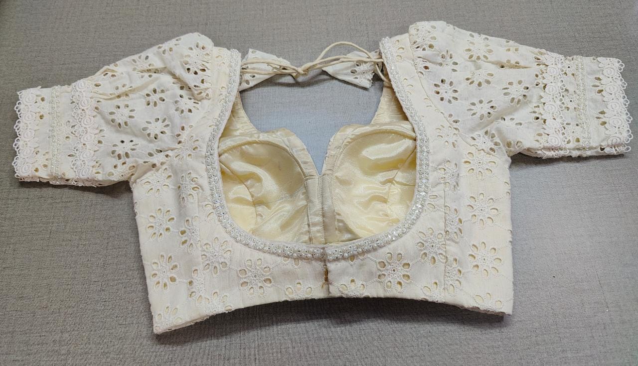 Buy white color Chikankari embroidery work saree blouse, has a U-neck, half puffy sleeves with hook & tie-up at the back. Pair it with cotton sarees to have a smooth and elegant look this summer. Elevate your Indian ethnic sarees with beautiful readymade sari blouses, embroidered saree blouses, Banarasi saree blouses, designer sari blouses, and choli-cut blouses from Pure Elegance Indian fashion store in USA.-Back View