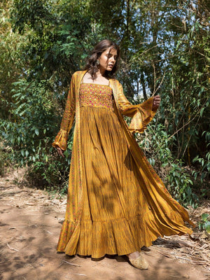 Buy stunning mustard printed maxi dress online in USA with cape jacket. Dazzle on weddings and special occasions with exquisite Indian designer dresses, sharara suits, Anarkali suits, wedding lehengas from Pure Elegance Indian fashion store in USA.-left