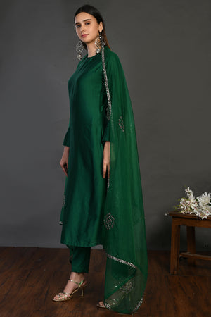 Buy bottle green cutdana work chanderi suit online in USA with dupatta. Dazzle on weddings and special occasions with exquisite Indian designer dresses, sharara suits, Anarkali suits, wedding lehengas from Pure Elegance Indian fashion store in USA.-left