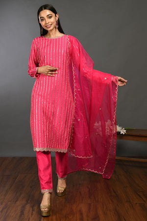 Shop rani pink mirror work silk suit online in USA with organza dupatta. Dazzle on weddings and special occasions with exquisite Indian designer dresses, sharara suits, Anarkali suits, wedding lehengas from Pure Elegance Indian fashion store in USA.-front