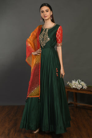 Buy beautiful bottle green muslin Anarkali suit online in USA with red orange dupatta. Dazzle on weddings and special occasions with exquisite Indian designer dresses, sharara suits, Anarkali suits, wedding lehengas from Pure Elegance Indian fashion store in USA.-left
