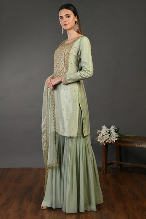 Buy sage green embroidered Mysore silk sharara suit online in USA with dupatta. Dazzle on weddings and special occasions with exquisite Indian designer dresses, sharara suits, Anarkali suits, wedding lehengas from Pure Elegance Indian fashion store in USA.-left