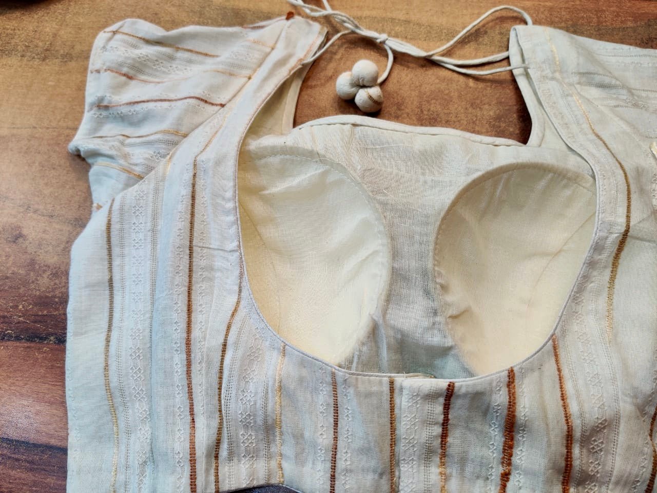 Shop gorgeous cream designer saree blouse online in USA with golden stripes. Elevate your ethnic saree style with a tasteful collection of designer sari blouses, embroidered saree blouses, Banarasi blouse, silk saree blouse from Pure Elegance Indian clothing store in USA.-back