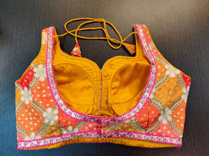 Buy beautiful yellow and orange embroidered Bandhej sleeveless saree blouse online in USA with pink embroidered lace. Elevate your ethnic sari style with a stunning collection of designer sari blouses, embroidered saree blouses, Banarasi sari blouse, fancy sari blouse from Pure Elegance Indian clothing store in USA.-back