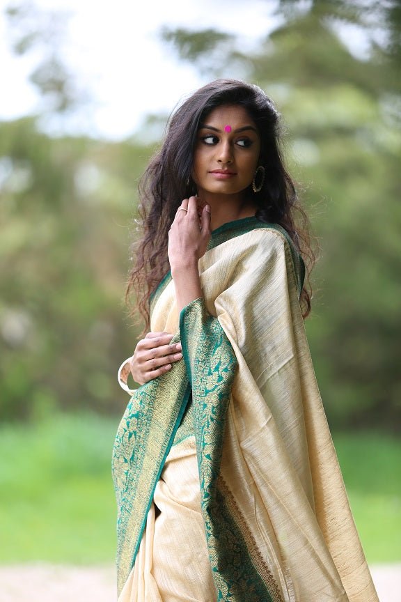Shop beautiful off-white tussar Benarasi saree online in USA with green zari border. Set high fashion standard with your beautiful collection of Indian designer sarees from Pure Elegance. Pick your favorite pure silk saris, traditional Banarasi sarees, embroidered saris from our exclusive Indian clothing store in USA.-closeup
