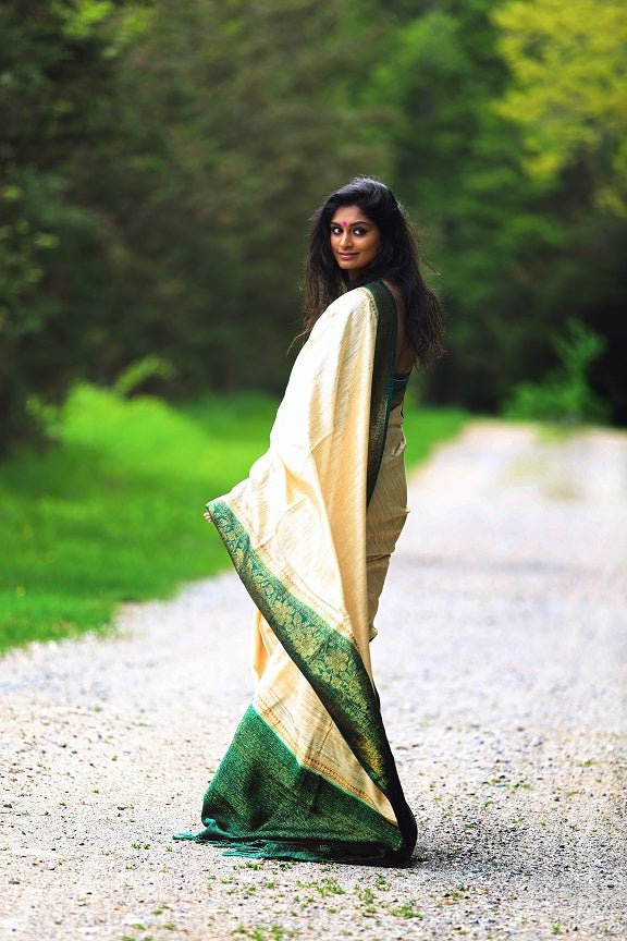 Shop beautiful off-white tussar Benarasi saree online in USA with green zari border. Set high fashion standard with your beautiful collection of Indian designer sarees from Pure Elegance. Pick your favorite pure silk saris, traditional Banarasi sarees, embroidered saris from our exclusive Indian clothing store in USA.-pallu
