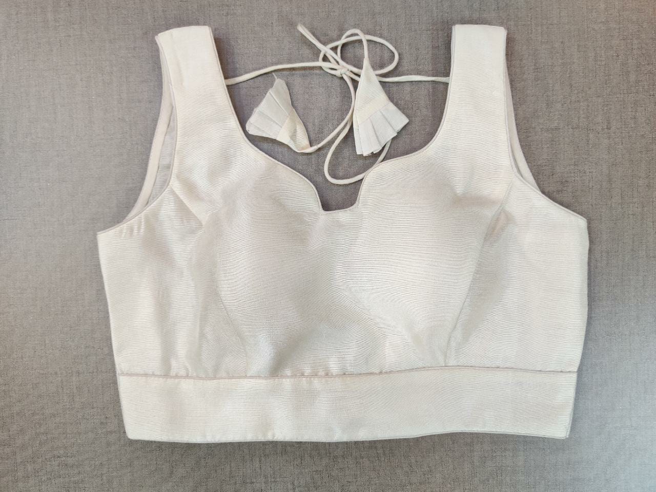 Shop gorgeous solid white sleeveless saree blouse online in USA. Elevate your Indian ethnic saree looks with beautiful readymade saree blouse, embroidered saree blouses, Banarasi saree blouse, designer sari blouses from Pure Elegance Indian fashion store in USA.-front