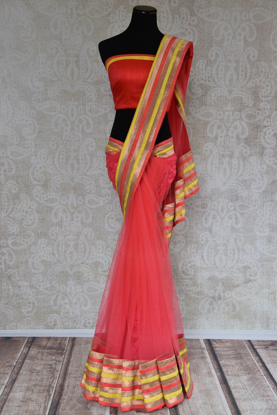 90A492 Coral red sari from India with multi-colored border & designer blouse. Buy this net saree, perfect for party wear, online at our Indian fashion store in USA - Pure Elegance. 