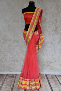 90A492 Coral red sari from India with multi-colored border & designer blouse. Buy this net saree, perfect for party wear, online at our Indian fashion store in USA - Pure Elegance. 