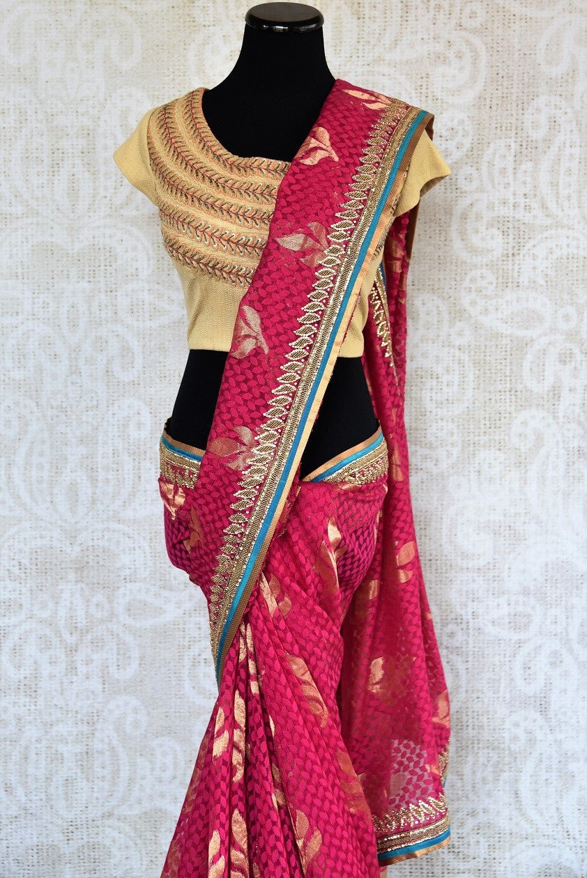 90a621 Traditional pink embroidered saree for sale online in USA. The jute Banarasi saree with golden leafy pattern comes with a beige, embroidered raw silk designer blouse. This saree makes for the perfect Indian outfit to wear at wedding functions and at Indian festive occasions.