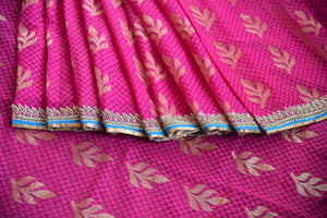 90a621 Traditional jute Banarasi embroidered saree for sale online in USA. The pink saree with golden leafy pattern comes with a beige, embroidered raw silk designer blouse. This saree makes for the perfect Indian outfit to wear at wedding functions and festivities. 