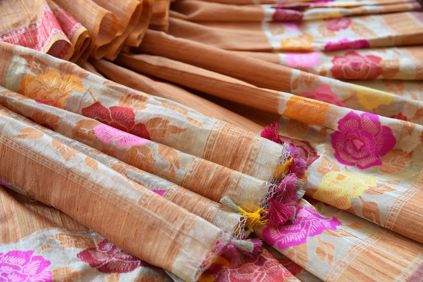 Tussar banarasi saree in orange yellow color with floral arrangement through the border and on pallu available in store Pure Elegance. Ideal pick for Parties.-close up of floral arrangement