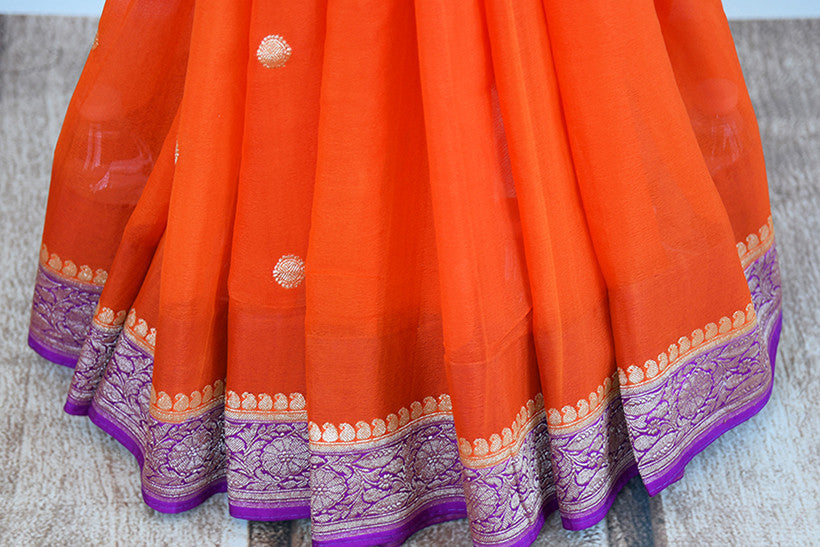Classic color combination of orange and purple in georgette banarasi saree. Perfect sari for festivals.- pleats