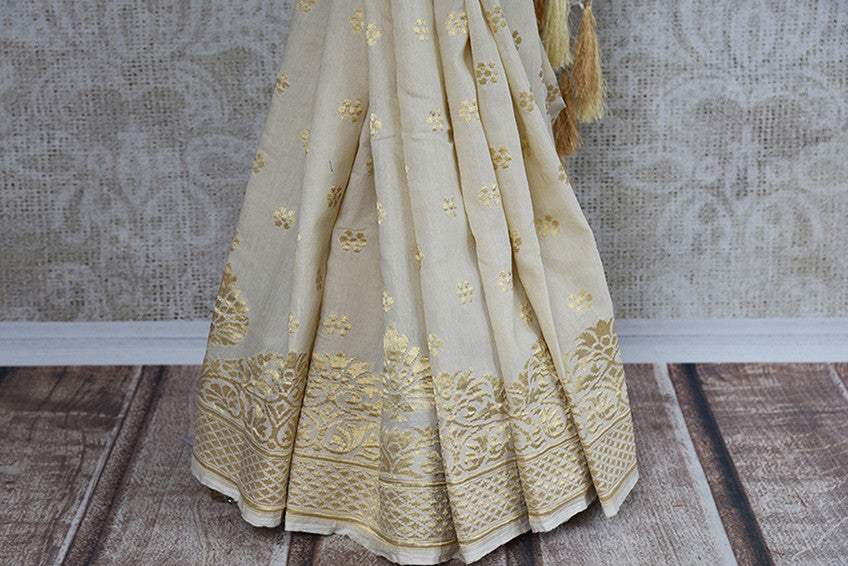 Classic and elegant off white hand woven muga banarasi saree. Perfect for festivals and pujas.-gold banarasi border